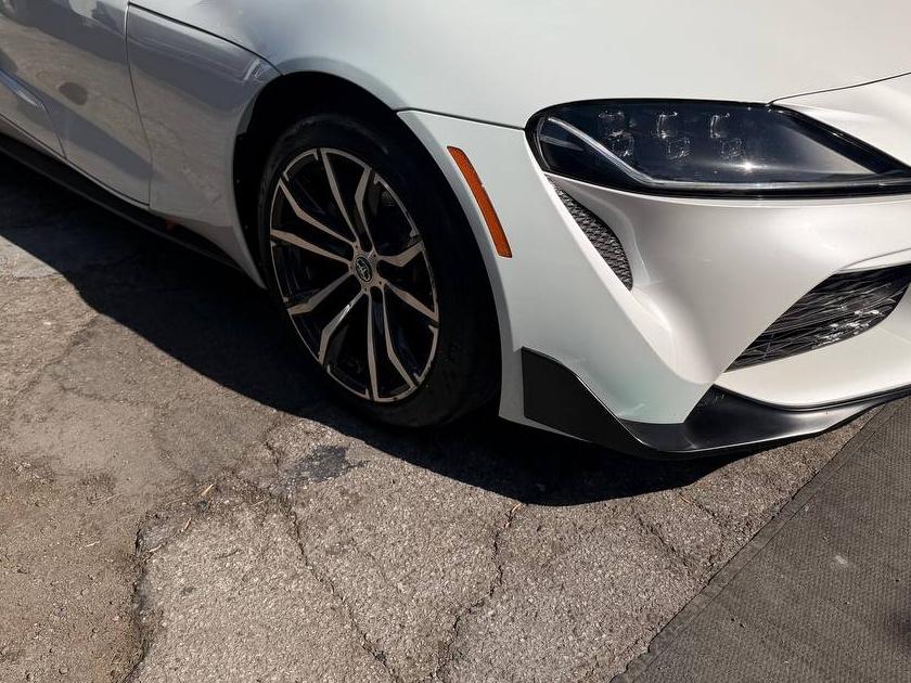 After repair: the same white Toyota Supra from the same front driver-side corner