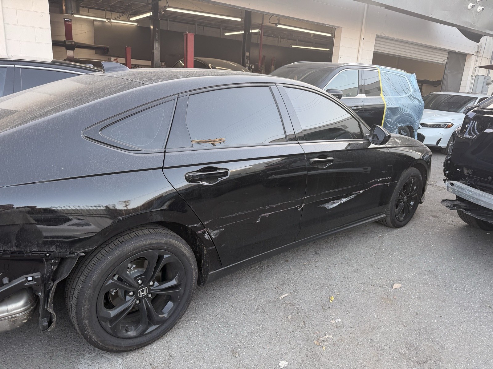 Honda Accord with visible front bumper, fender, and door collision damage before repair